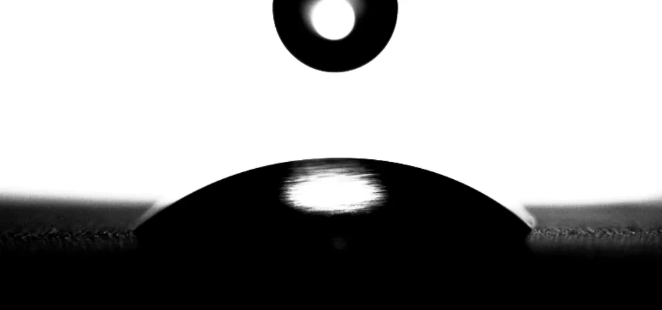 Water drop on aluminum at 13.6 °C, spread flat with a low contact angle.