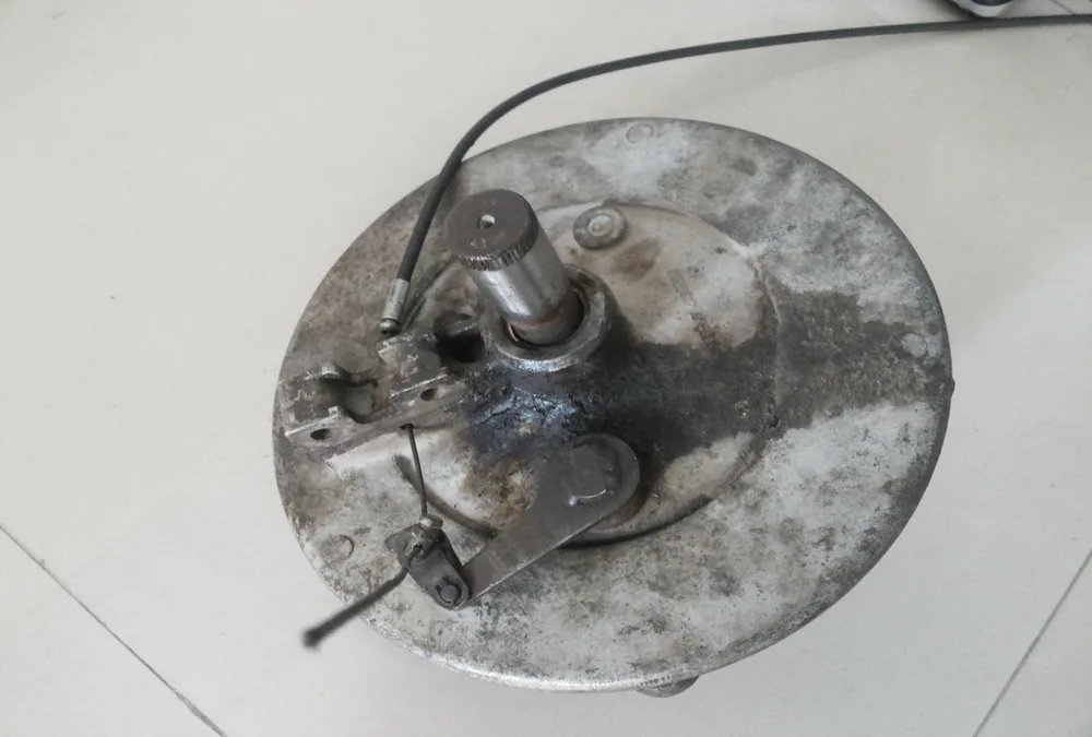 The drum brake backing plate with its lever and cable.